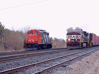 328 with NS 9796 in lead blows past the local CN switcher in Ingersoll. Kinda like David and Goliath, that little GP9 seems to be cowering to its bigger cousin 4/1/04